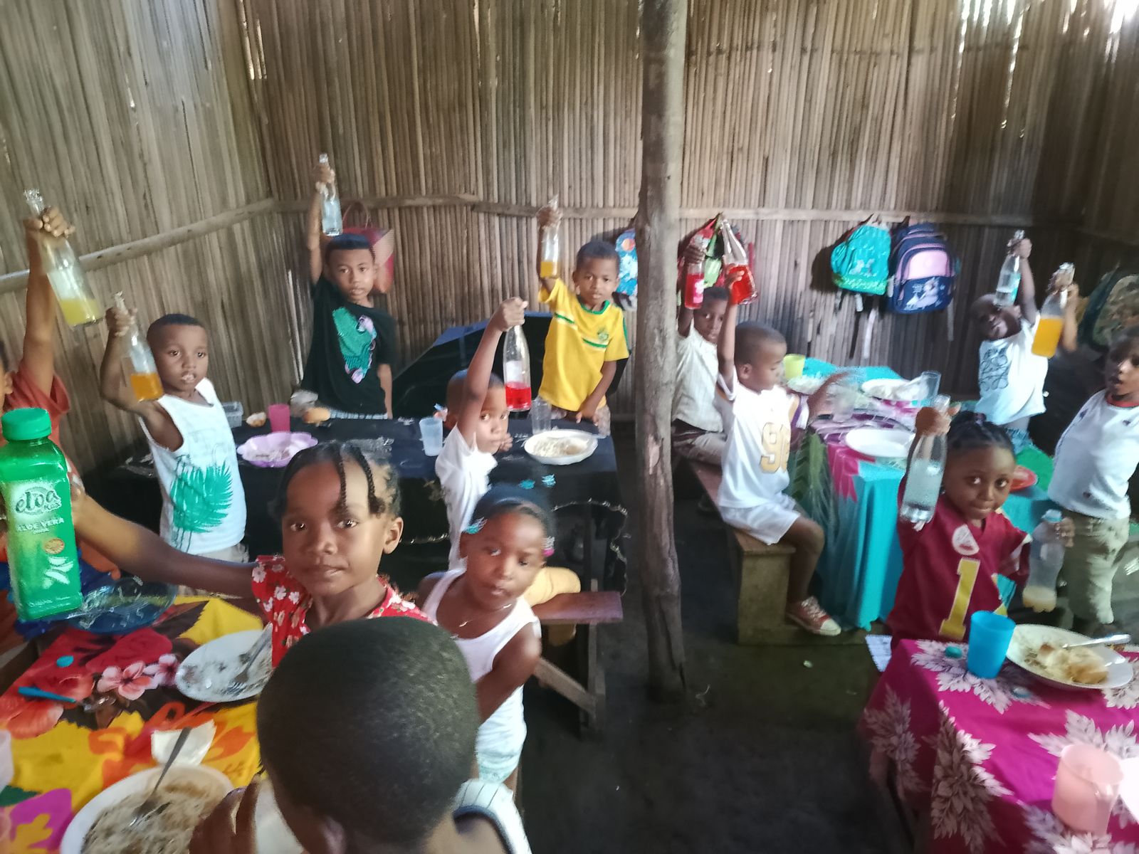 Enfants d'ELIMA levant leur boisson lors de la fête de l'école